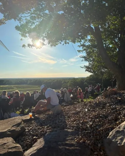 A summer concert crowd on the hill at sunset